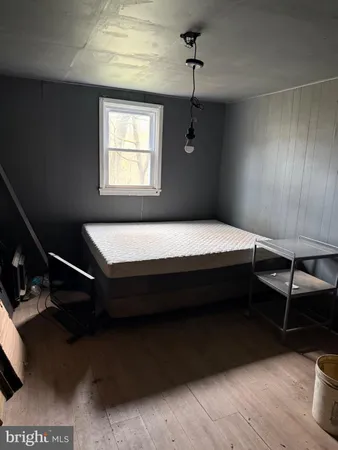 a bedroom with a bed wooden floor and window