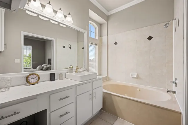 a spacious bathroom with a tub a double vanity sink and mirror