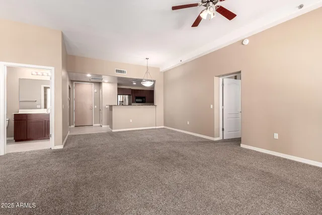 an empty room with windows and fireplace