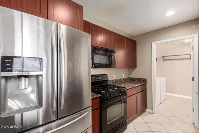 a kitchen with stainless steel appliances granite countertop a sink a oven and a refrigerator