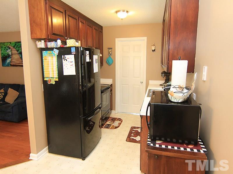 4009 Rockside Hills Drive Raleigh, NC 27603 - Photo 11 of 25 a kitchen with stainless steel appliances kitchen island granite countertop a refrigerator and a stove