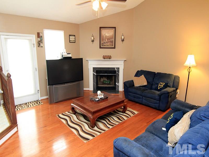 4009 Rockside Hills Drive Raleigh, NC 27603 - Photo 6 of 25 a living room with furniture flat screen tv and a fireplace