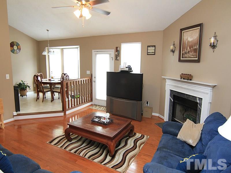 4009 Rockside Hills Drive Raleigh, NC 27603 - Photo 7 of 25 a living room with furniture fireplace and dining table