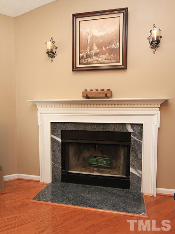 4009 Rockside Hills Drive Raleigh, NC 27603 - Photo 8 of 25 a living room with a fireplace and a wooden floor