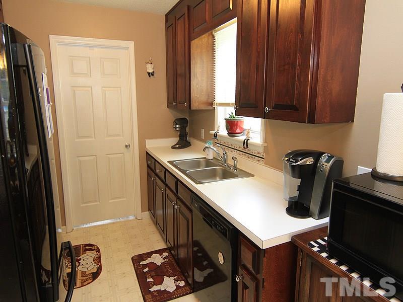 4009 Rockside Hills Drive Raleigh, NC 27603 - Photo 9 of 25 a kitchen with a sink a stove and a refrigerator