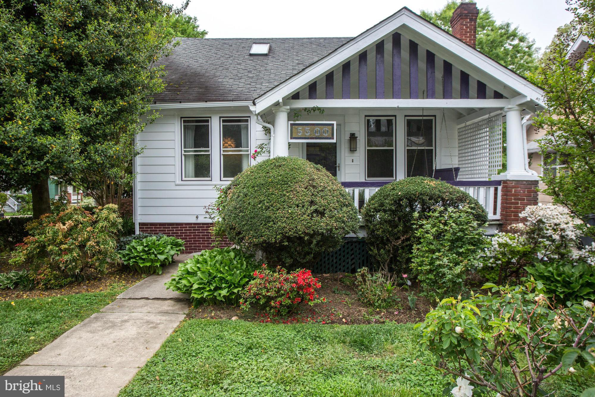 a front view of a house with a yard and flower plants