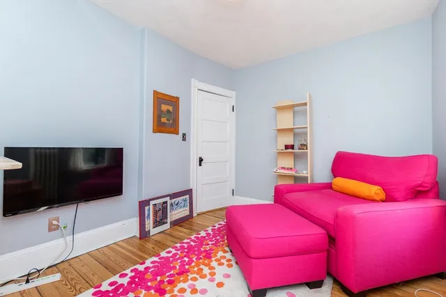 a living room with a bed and a flat screen tv