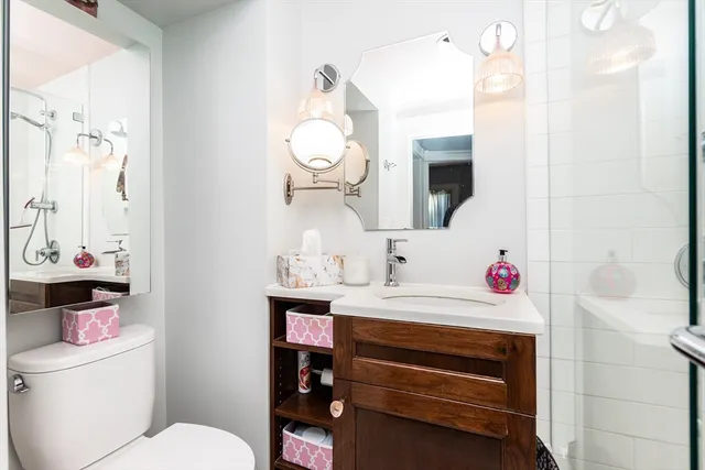 a bathroom with a sink vanity mirror and toilet