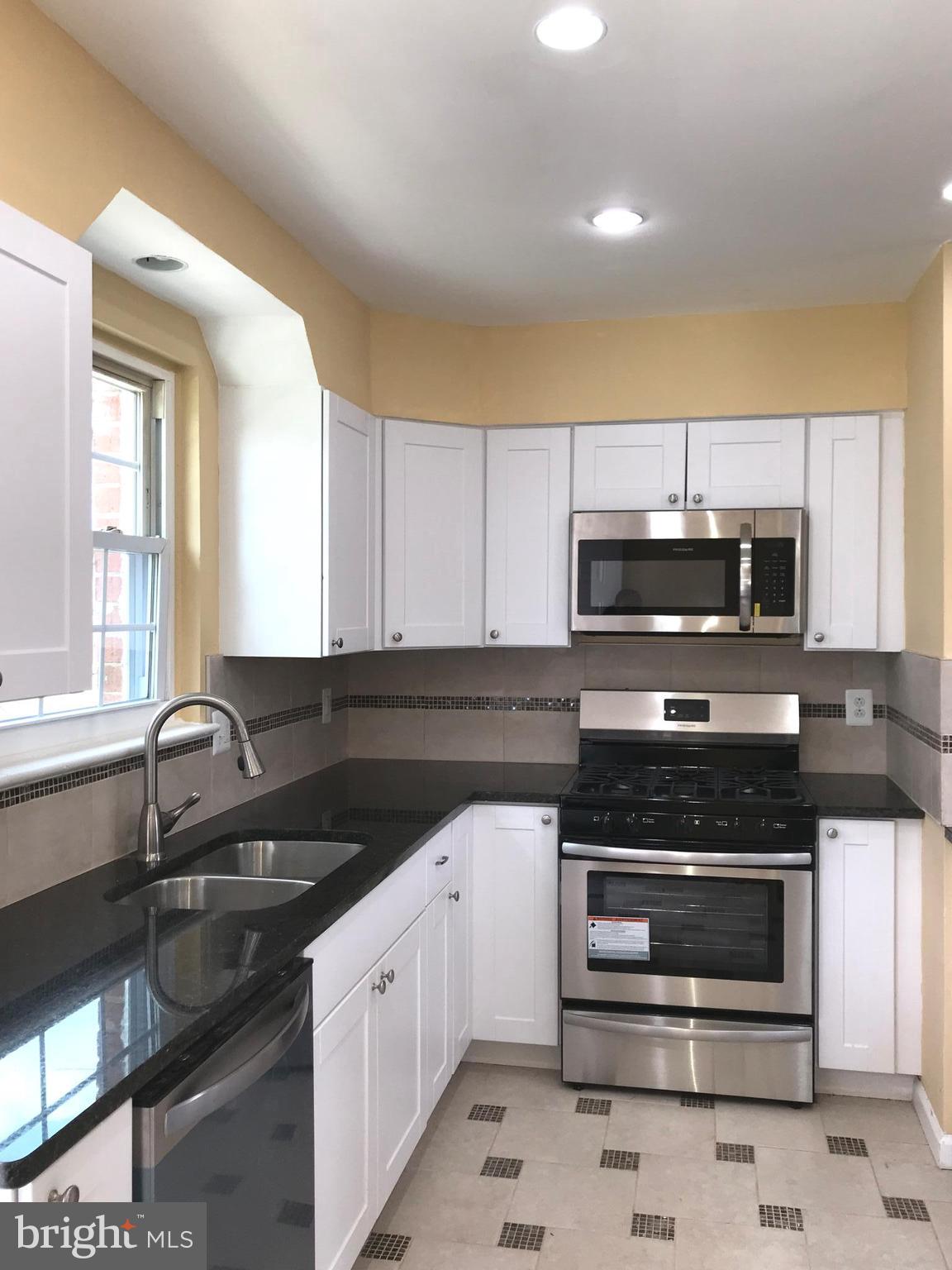 7900 Riggs Road Hyattsville, MD 20783 - Photo 8 of 9 a kitchen with stainless steel appliances a stove a sink and a microwave