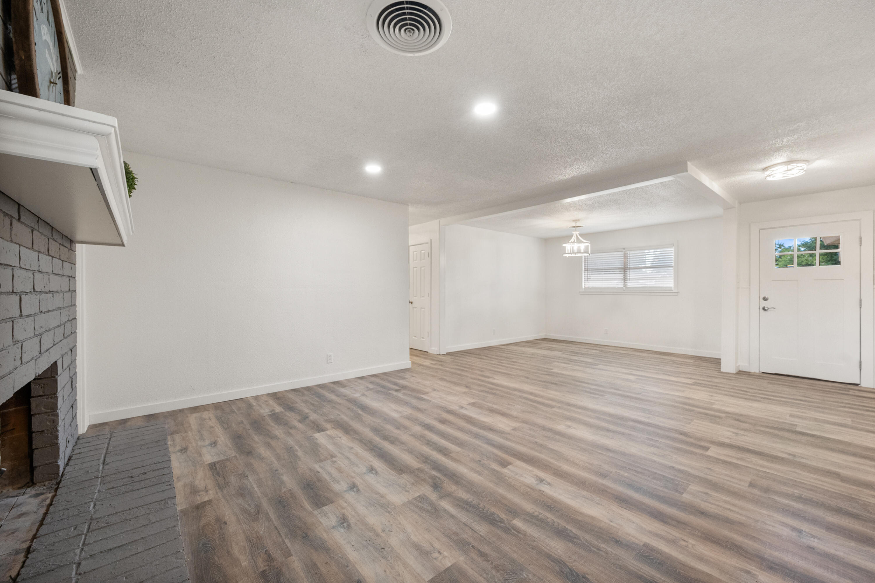 816 Cedar Street Floydada, TX 79235 - Photo 5 of 24 an empty room with wooden floor and windows