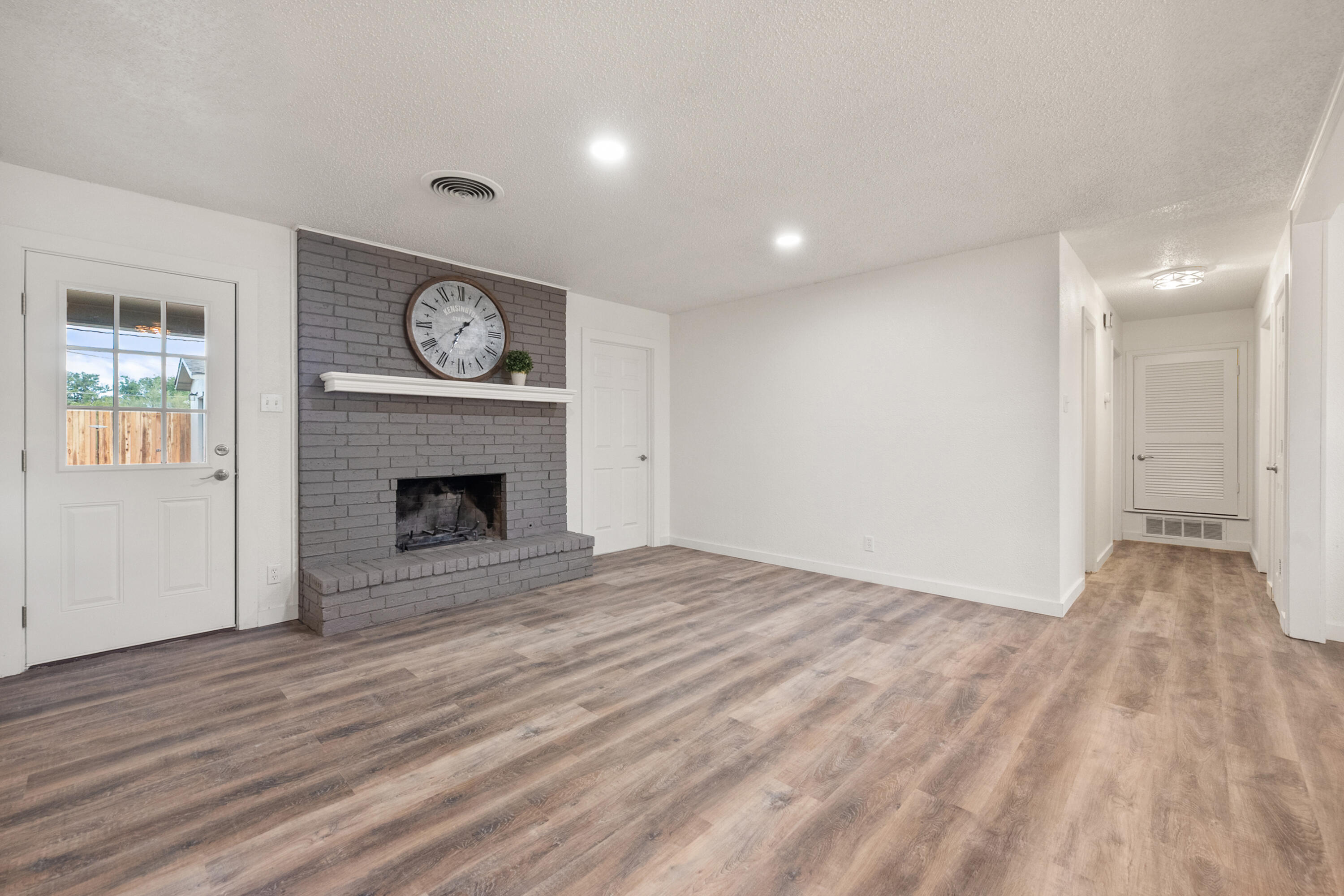 816 Cedar Street Floydada, TX 79235 - Photo 6 of 24 a view of an empty room with wooden floor and a fireplace