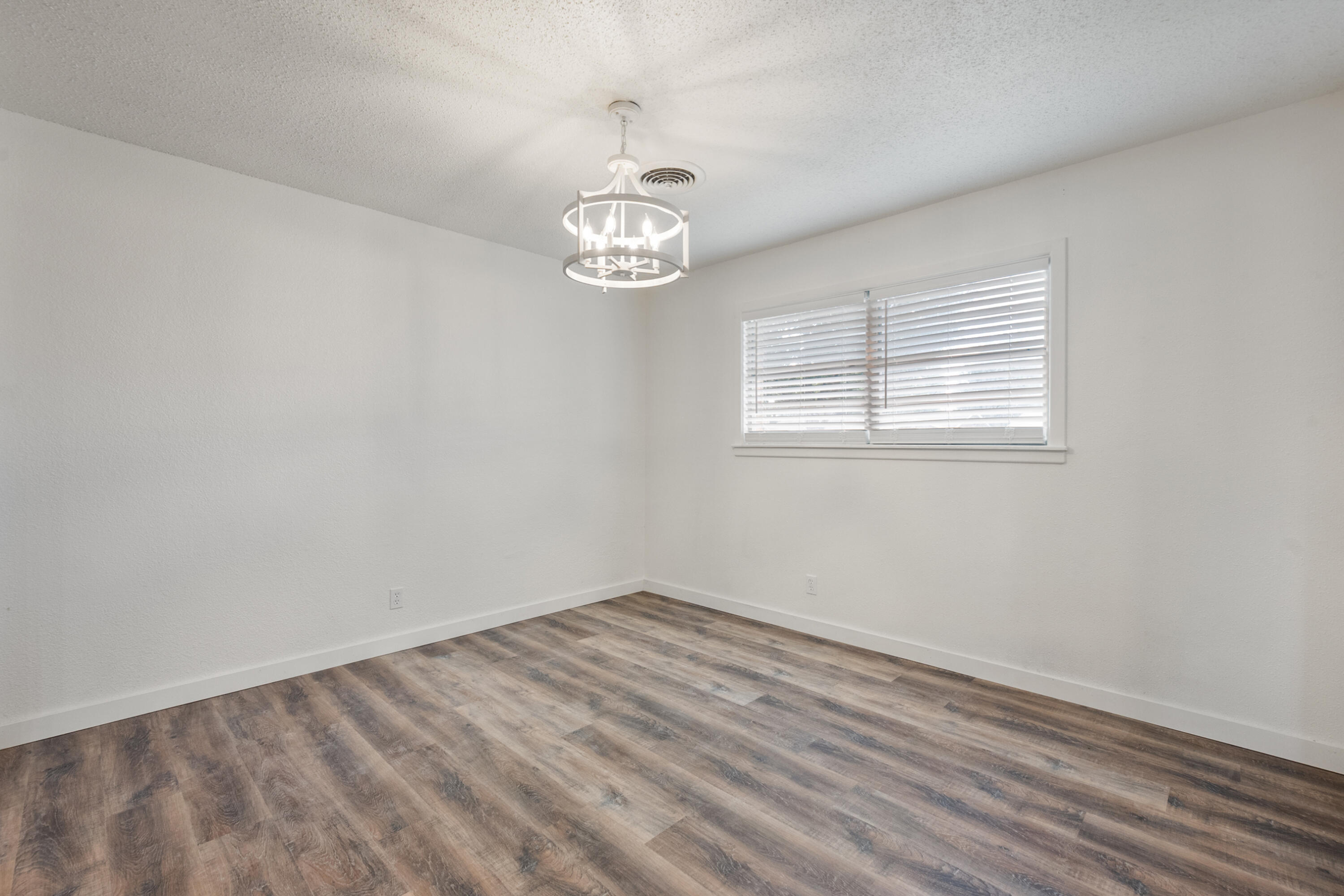 816 Cedar Street Floydada, TX 79235 - Photo 7 of 24 an empty room with wooden floor and window