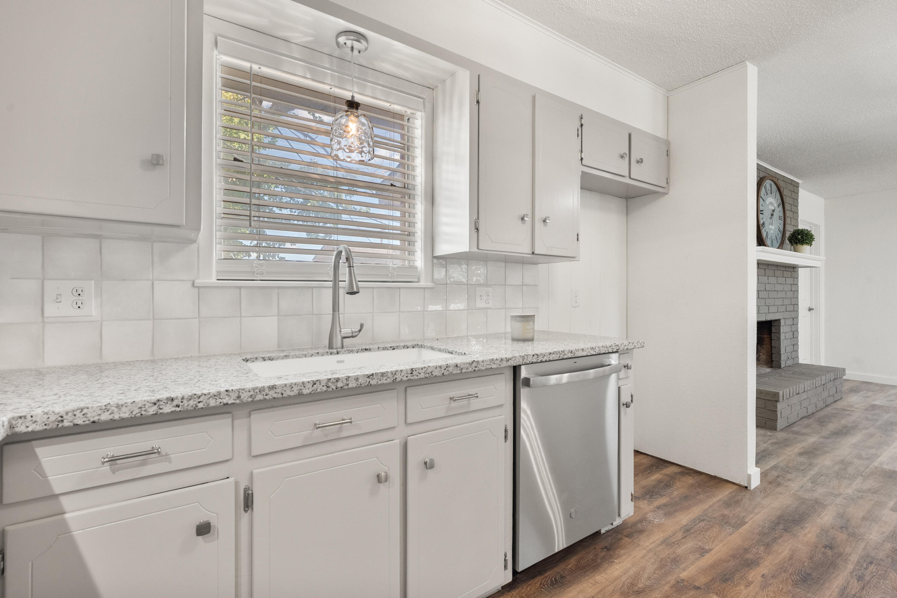 816 Cedar Street Floydada, TX 79235 - Photo 10 of 24 a kitchen with stainless steel appliances granite countertop white cabinets and window