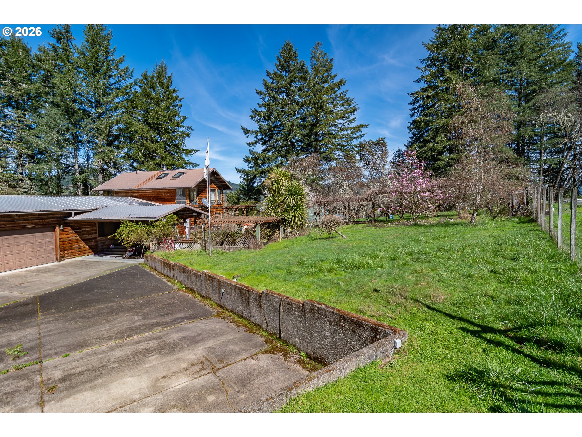 4890 Henderer Road Elkton, OR 97436 - Photo 45 of 48 a view of a backyard with table and chairs under an umbrella