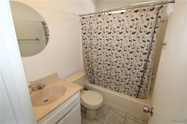 a bathroom with a granite countertop toilet and a sink