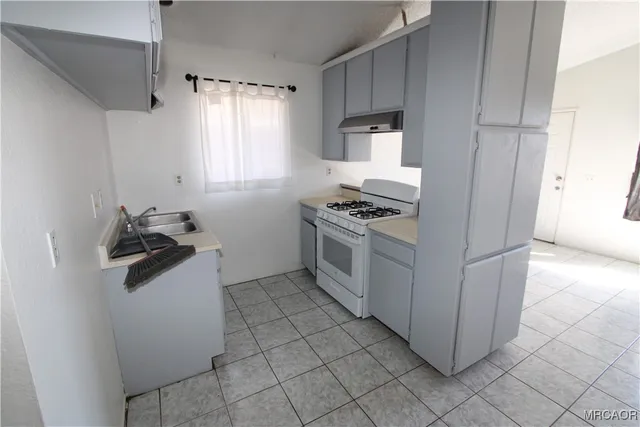 a kitchen with a stove top oven and cabinets