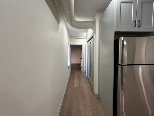 a view of a hallway with wooden floor and staircase