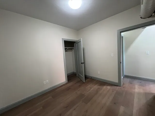 an empty room with wooden floor and closet