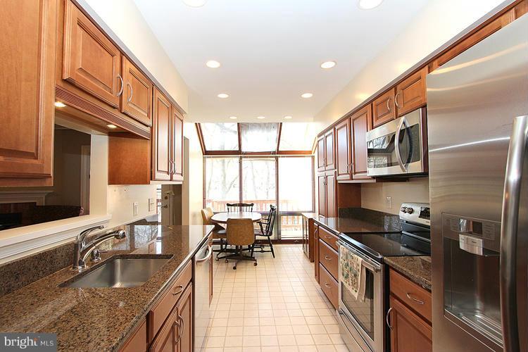 10922 Brewer House Road Rockville, MD 20852 - Photo 11 of 27 a kitchen with stainless steel appliances granite countertop a sink a stove and a wooden cabinets