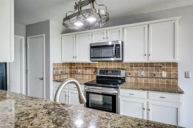 a kitchen with stainless steel appliances a stove microwave and sink