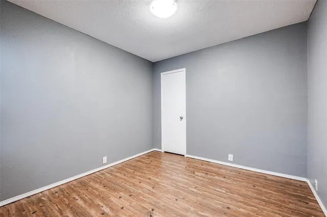 a view of room with wooden floor and white walls