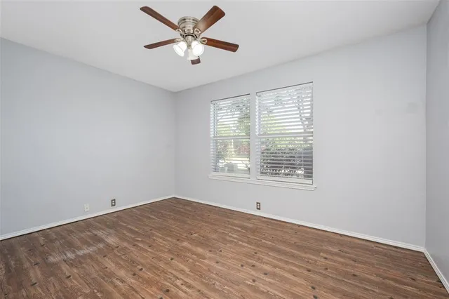 a view of an empty room with a window and a ceiling fan