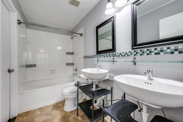 a bathroom with a sink toilet tub and shower