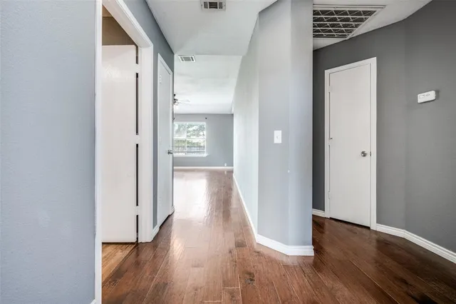 a view of a hallway with wooden floor