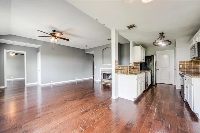 a view of kitchen view wooden floors appliances and cabinets