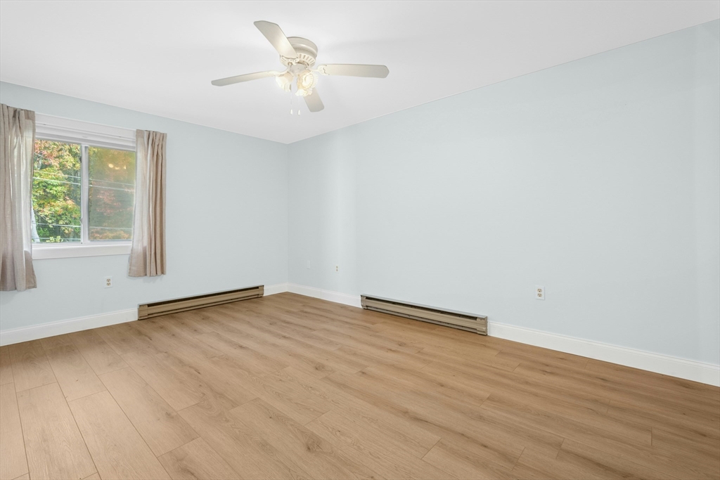10 Erick Road, Unit 34 Mansfield, MA 02048 - Photo 15 of 24 a view of an empty room with wooden floor and a window