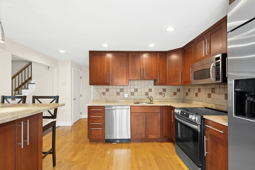 10 Erick Road, Unit 34 Mansfield, MA 02048 - Photo 8 of 24 a kitchen with stainless steel appliances granite countertop a sink stove and refrigerator