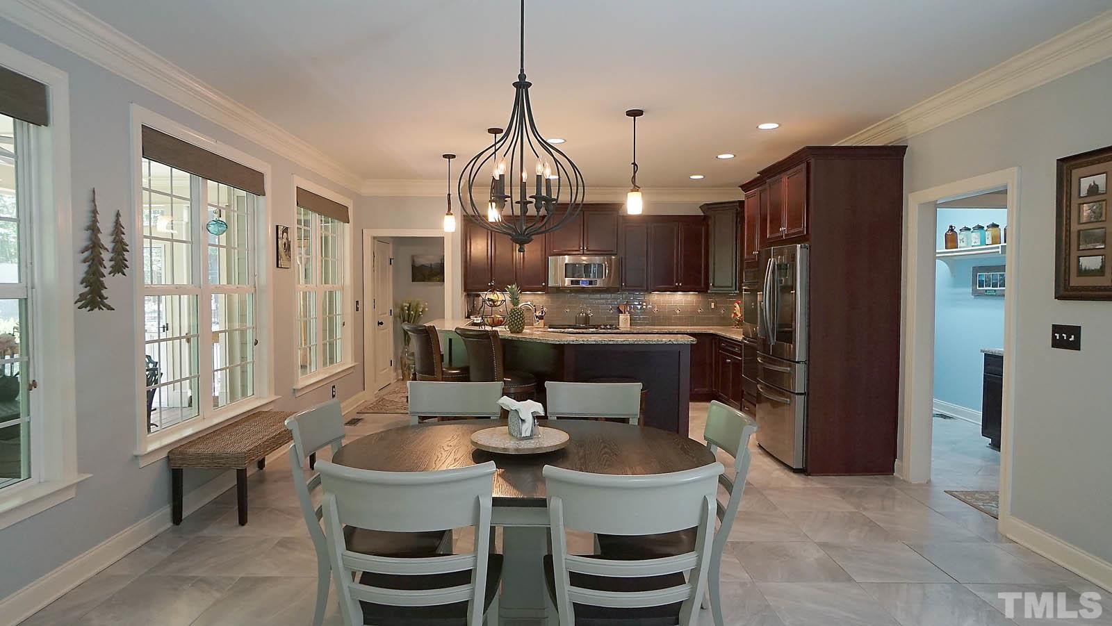 275 Hawfields Drive Pittsboro, NC 27312 - Photo 10 of 44 a dining room with furniture a large window and stainless steel appliances