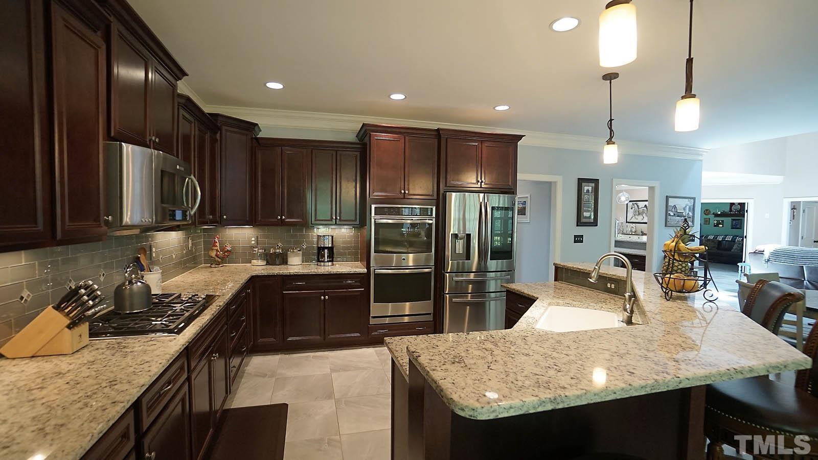 275 Hawfields Drive Pittsboro, NC 27312 - Photo 12 of 44 a kitchen with stainless steel appliances granite countertop sink stove refrigerator and cabinets