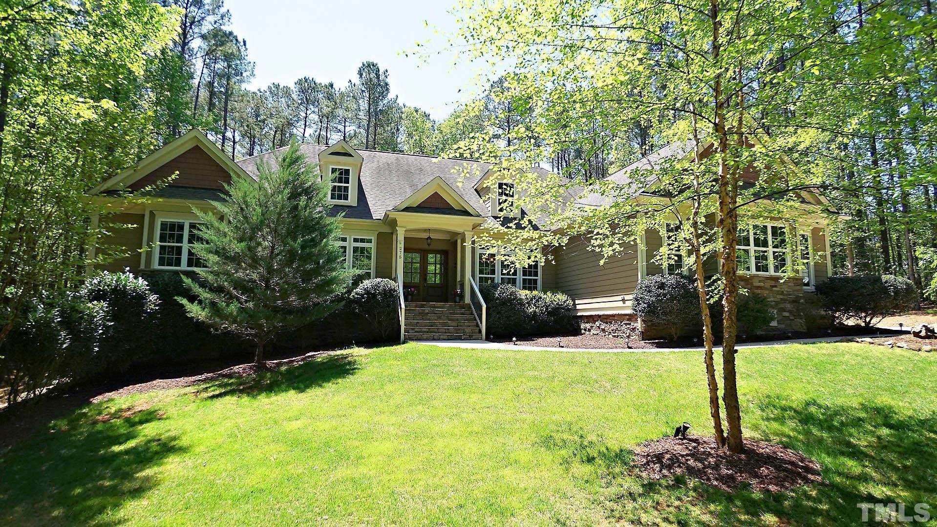 a view of a house with big yard and large trees