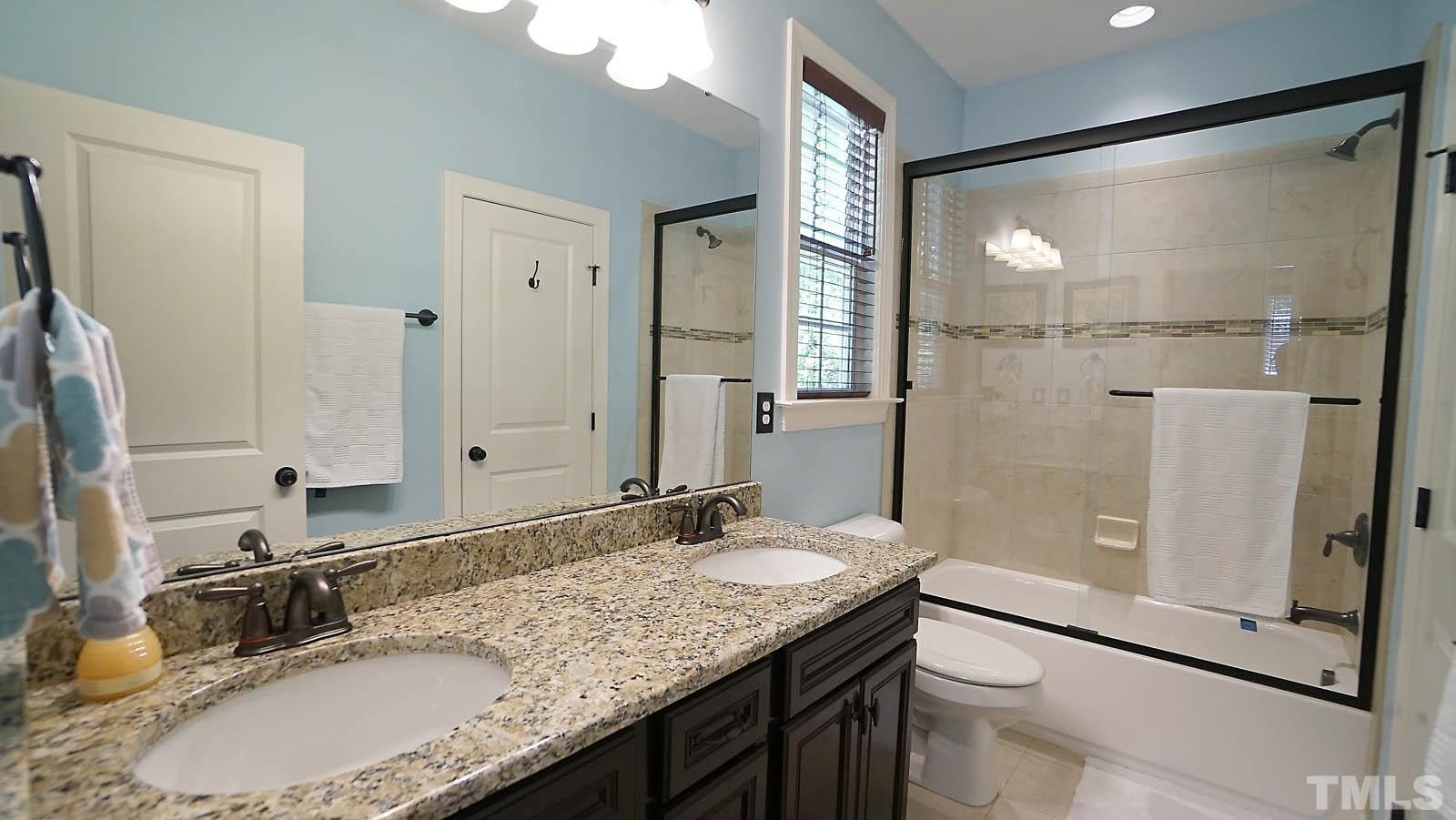 275 Hawfields Drive Pittsboro, NC 27312 - Photo 33 of 44 a bathroom with a granite countertop sink a mirror and a shower