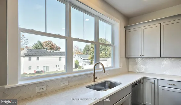 a kitchen with a sink and cabinets next to a window