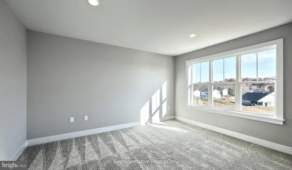 a view of empty room with window and wooden floor