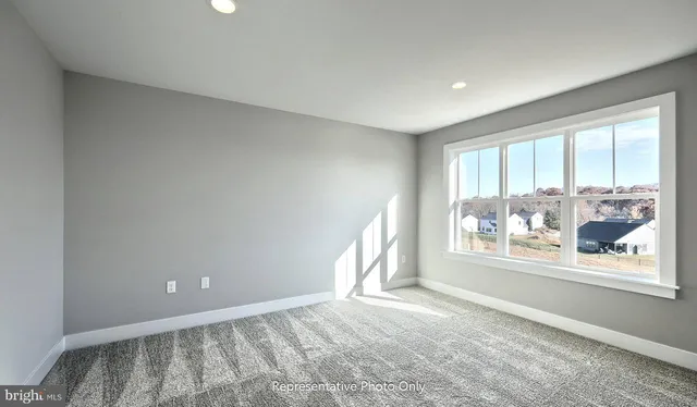 a view of empty room with window and wooden floor
