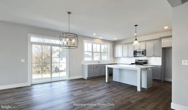 a kitchen with stainless steel appliances granite countertop a stove oven and a wooden floors