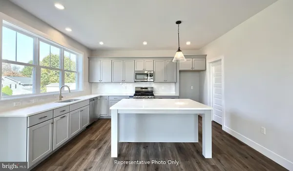 a kitchen with a sink a center island cabinets and a window
