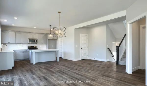 a kitchen with white cabinets and wooden floor