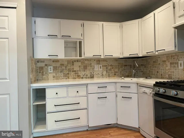 a kitchen with granite countertop white cabinets and white appliances