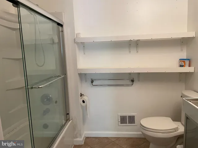 a bathroom with a shower a toilet and sink