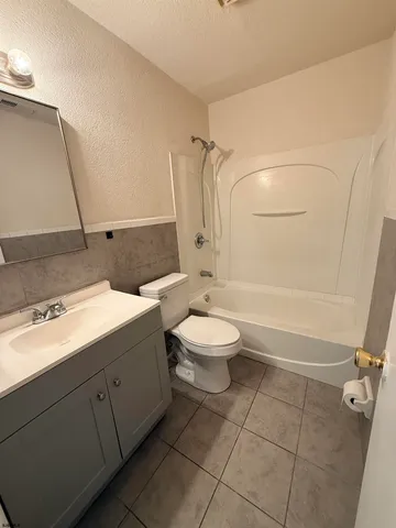 a bathroom with a granite countertop sink toilet a mirror and shower