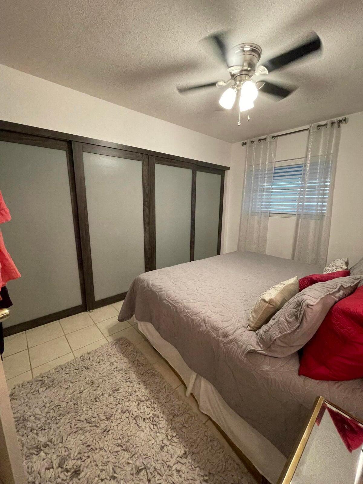 2131 Northeast 42nd Court, Unit 210E Lighthouse Point, FL 33064 - Photo 14 of 22 a bedroom with a large bed and a chandelier