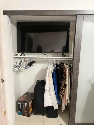 a view of walk in closet with clothes
