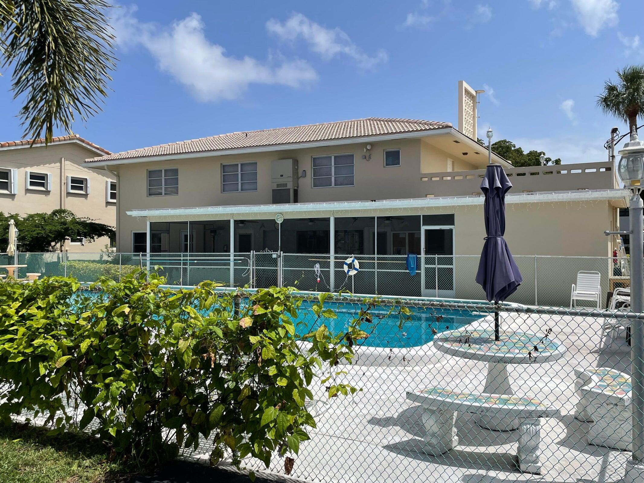 2131 Northeast 42nd Court, Unit 210E Lighthouse Point, FL 33064 - Photo 22 of 22 a front view of a house with garden and parking