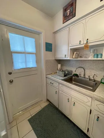 a kitchen with granite countertop white cabinets and sink