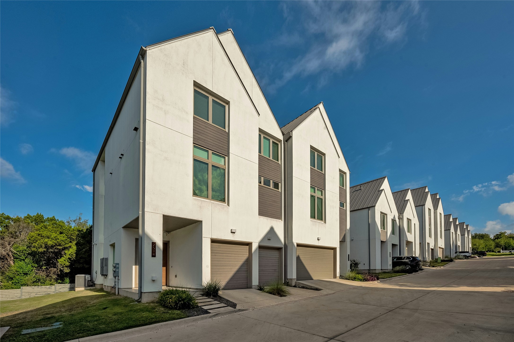 2518 Sutherland Street Austin, TX 78746 - Photo 3 of 30 Modern townhomes line the street, each boasting striking architectural lines and integrated garages.