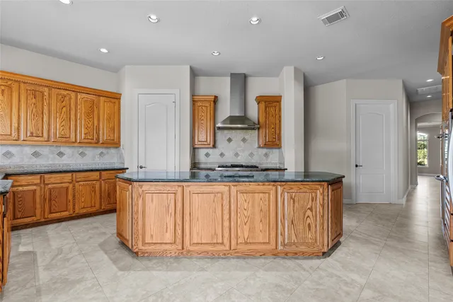 a kitchen with granite countertop a stove a sink dishwasher and a microwave oven with wooden floor